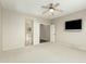 Bright bedroom featuring neutral carpet, a ceiling fan, and a television mounted on the wall at 41216 N Shadow Creek Ct, Anthem, AZ 85086