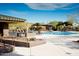 Inviting community pool area with ample lounge chairs, shaded cabanas, and lush desert landscaping at 41216 N Shadow Creek Ct, Anthem, AZ 85086