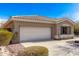 Exterior shot of a home showing a two-car garage, desert landscaping, and a neutral-colored facade on a sunny day at 41216 N Shadow Creek Ct, Anthem, AZ 85086