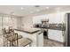 Well-lit kitchen featuring a breakfast bar, stainless steel appliances, and white cabinetry at 41216 N Shadow Creek Ct, Anthem, AZ 85086