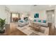 Inviting living room featuring hardwood floors, modern furniture, and an open layout to the dining area at 41216 N Shadow Creek Ct, Anthem, AZ 85086