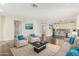 Open-concept living room with hardwood floors, comfortable seating, and a smooth transition into the dining area at 41216 N Shadow Creek Ct, Anthem, AZ 85086