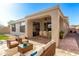 Charming outdoor patio featuring a covered seating area, stone flooring, and a cozy ambiance for relaxation at 41216 N Shadow Creek Ct, Anthem, AZ 85086