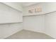 Bright walk-in closet with ample shelving and a view from small upper windows to the outside at 41216 N Shadow Creek Ct, Anthem, AZ 85086