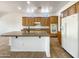 Kitchen with an island, wood cabinets, and modern appliances at 42950 W Misty Morning Ln, Maricopa, AZ 85138