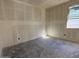 Unfinished walls in a spacious bedroom awaiting customization, offering natural light through a window at 4509 S 95Th Dr, Tolleson, AZ 85353