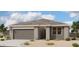 Single-story home with gray exterior, a two-car garage, and landscaping at 46820 W Cansados Rd, Maricopa, AZ 85139