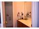 Bathroom featuring a shower-tub combo, oak cabinets, and a neutral countertop with mirror above the vanity at 7712 S 25Th Ave, Phoenix, AZ 85041