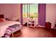 Bright bedroom with wood floor, bed with colorful accent blanket, accent furniture, and natural light from the large window at 7712 S 25Th Ave, Phoenix, AZ 85041