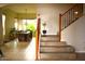 Inviting foyer featuring tile flooring, staircase with iron railing, and open dining room at 7712 S 25Th Ave, Phoenix, AZ 85041