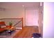 Bright loft with wood floors, orange sofa, wrought iron railing, a closed closet door, and natural lighting at 7712 S 25Th Ave, Phoenix, AZ 85041