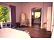 An archway leads to the bathroom in this main bedroom with wood floors and a large window at 7712 S 25Th Ave, Phoenix, AZ 85041