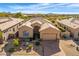 Aerial view of a beautiful desert home featuring lush landscaping, a tile roof, and a spacious driveway at 9523 E Sandy Vista Dr, Scottsdale, AZ 85262