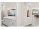 Modern bathroom with dual sinks, sleek cabinetry, a large mirror, and a view of desert scenery at 9523 E Sandy Vista Dr, Scottsdale, AZ 85262