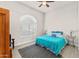 Bright bedroom with a ceiling fan, tiled floor, large window, and a comfortable bed with blue bedding at 9523 E Sandy Vista Dr, Scottsdale, AZ 85262