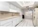 White kitchen with ample storage and a window at 9719 W Newport Dr, Sun City, AZ 85351