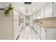 Efficient kitchen with white cabinetry and tile flooring at 9719 W Newport Dr, Sun City, AZ 85351