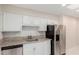 Updated kitchen features granite countertops, stainless steel appliances, and white cabinetry at 10450 W Campana Dr, Sun City, AZ 85351