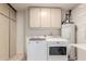 Bright laundry room, washer, dryer, cabinets, and water heater at 10450 W Campana Dr, Sun City, AZ 85351