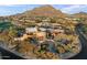 An aerial view of a large estate home surrounded by mature landscaping and a mountain backdrop at 10801 E Happy Valley Rd # 102, Scottsdale, AZ 85255