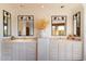 Dual vanity bathroom with decorative mirrors and white cabinetry at 10801 E Happy Valley Rd # 102, Scottsdale, AZ 85255
