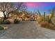 Beautiful desert home exterior with mature landscaping and a brick driveway at 10801 E Happy Valley Rd # 102, Scottsdale, AZ 85255
