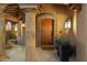 Covered entry featuring stone columns and a decorative wood front door at 10801 E Happy Valley Rd # 102, Scottsdale, AZ 85255