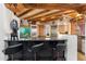 Rustic kitchen with wood beam ceilings, black countertops, tile backsplash, and stainless steel appliances at 10801 E Happy Valley Rd # 102, Scottsdale, AZ 85255