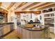 Open kitchen features a granite island, stainless steel appliances, and rustic wooden beam accents overhead at 10801 E Happy Valley Rd # 102, Scottsdale, AZ 85255
