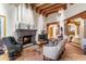 Stately living room featuring beamed ceilings, a stone fireplace, and terra cotta flooring throughout at 10801 E Happy Valley Rd # 102, Scottsdale, AZ 85255