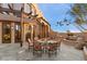 Elegant outdoor dining area featuring a pergola, stone patio, and desert landscaping, perfect for al fresco dining and entertaining at 10801 E Happy Valley Rd # 102, Scottsdale, AZ 85255