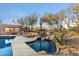 Lush pool area featuring desert landscaping, comfortable lounge chairs, and a serene waterfall for relaxation and enjoyment at 10801 E Happy Valley Rd # 102, Scottsdale, AZ 85255
