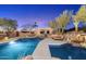 Desert home featuring a private pool, rock waterfall, and ample lounge seating, perfect for outdoor relaxation at 10801 E Happy Valley Rd # 102, Scottsdale, AZ 85255