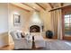 Comfortable sitting room with a fireplace, wooden beams, and plush seating offering relaxation and warmth at 10801 E Happy Valley Rd # 102, Scottsdale, AZ 85255