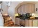 This wet bar offers a mini fridge, granite countertop, black tile backsplash, and classic wood cabinetry at 10801 E Happy Valley Rd # 102, Scottsdale, AZ 85255