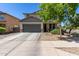 Two-story house with a gray garage door and landscaping at 15528 W Poinsettia Dr, Surprise, AZ 85379