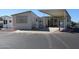 Tan mobile home with covered patio and parking area at 17200 W Bell Rd # 873, Surprise, AZ 85374