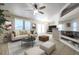 Bright living room with a ceiling fan, tan sofas, decorative pillows, and a gray rug at 17200 W Bell Rd # 873, Surprise, AZ 85374