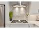 Modern gas cooktop with white tile backsplash in kitchen at 2038 E Dry Wood Rd, Phoenix, AZ 85024