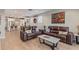 Open floor plan living room with kitchen view, leather sofas, and hardwood floors at 2038 E Dry Wood Rd, Phoenix, AZ 85024