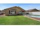 Well-maintained backyard featuring green lawn, a pool, and neutral colored exterior at 2234 E Stephens Rd, Gilbert, AZ 85296