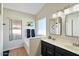 Bright bathroom with double sinks, decorative mirrors, and a soaking tub with window at 2234 E Stephens Rd, Gilbert, AZ 85296