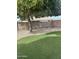 A spacious backyard with artificial turf, gravel, and a mature tree providing plenty of shade at 2364 S Minneola Ln, Gilbert, AZ 85295