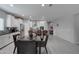 Open-concept dining area adjacent to a modern kitchen with white cabinets and stainless appliances at 25978 W Marco Polo Rd, Buckeye, AZ 85396