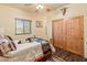 Cozy bedroom features wood floors, ceiling fan, and picture window at 38860 N School House Rd, Cave Creek, AZ 85331