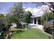 Landscaped backyard with a pool, patio, lush lawn, garden, and mature trees at 4119 E Glencove St, Mesa, AZ 85205