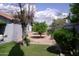 Grassy backyard featuring a lemon tree, other mature trees and shrubs enclosed by a block wall at 4119 E Glencove St, Mesa, AZ 85205