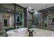 Modern bathroom featuring a soaking tub, glass-enclosed shower, and large windows offering natural light at 4451 E Joshua Tree Ln, Paradise Valley, AZ 85253