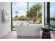 Luxurious bathroom with a standalone tub and backyard views at 4451 E Joshua Tree Ln, Paradise Valley, AZ 85253