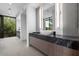 Bathroom featuring a vessel sink on a dark marble counter with wood cabinets and a window view at 4451 E Joshua Tree Ln, Paradise Valley, AZ 85253